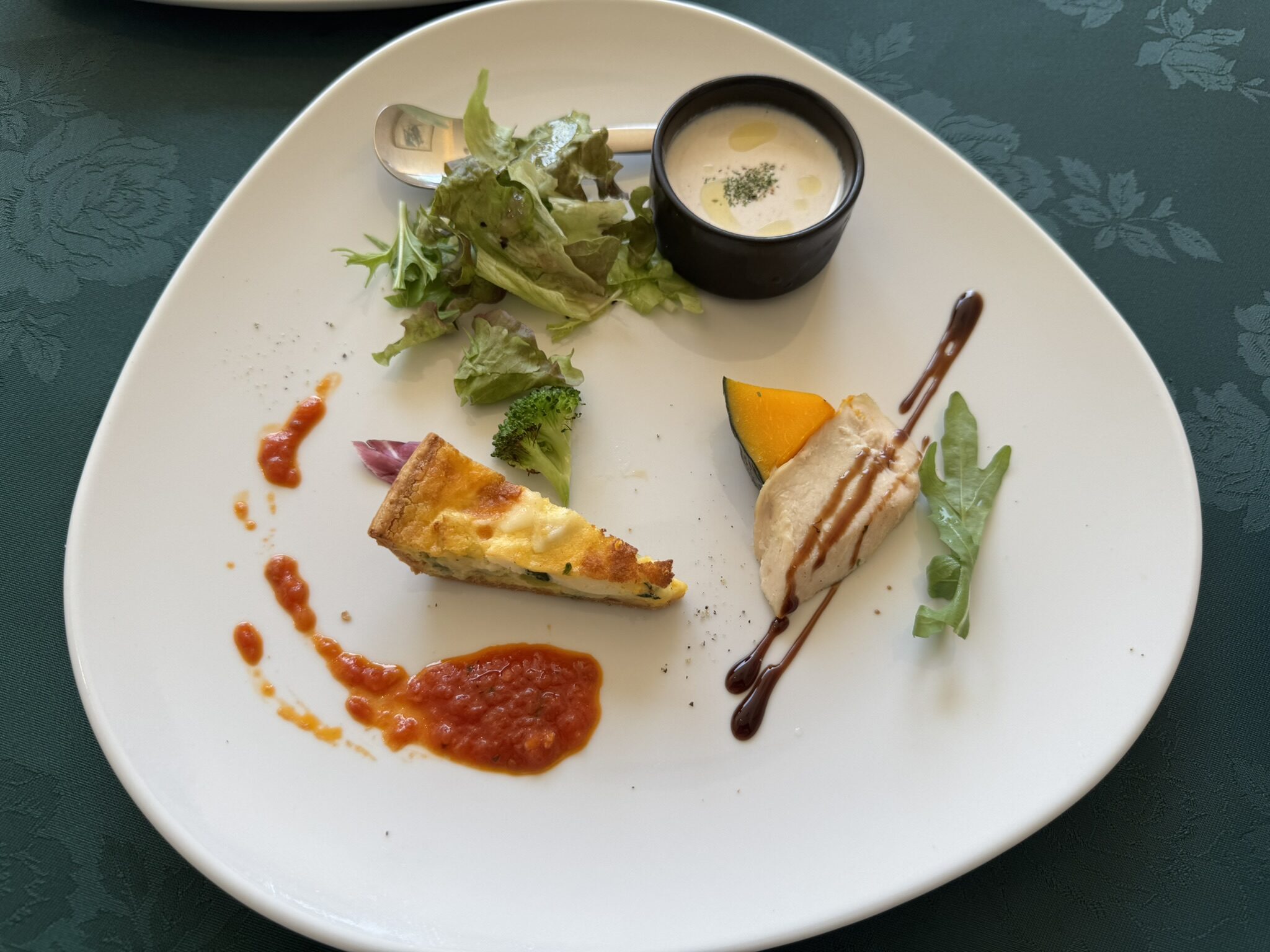 前菜の盛り合わせ(ごぼうのポタージュ、ほうれん草と白身魚のキッシュ、蒸し鶏のような料理にバルサミコソース)の写真