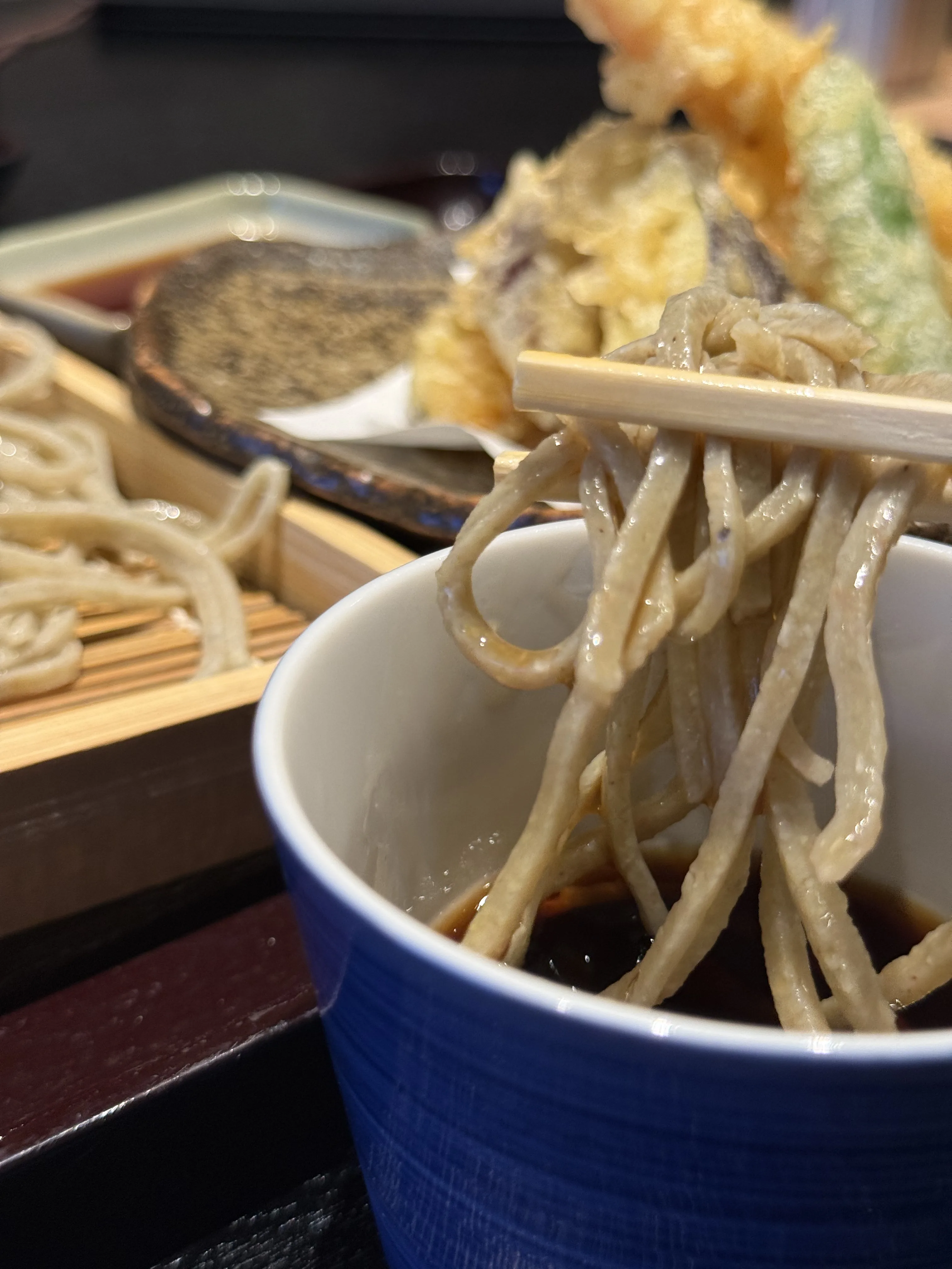 『手打ち蕎麦 きさく』天麩羅ざるそばのつゆにつけた写真